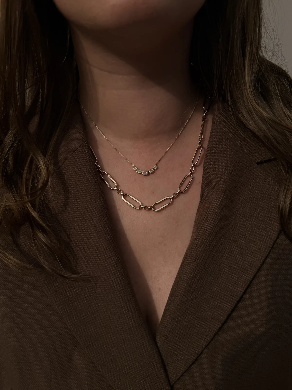 14k yellow gold fancy oval link necklace layered under a baguette bezel-set diamond necklace