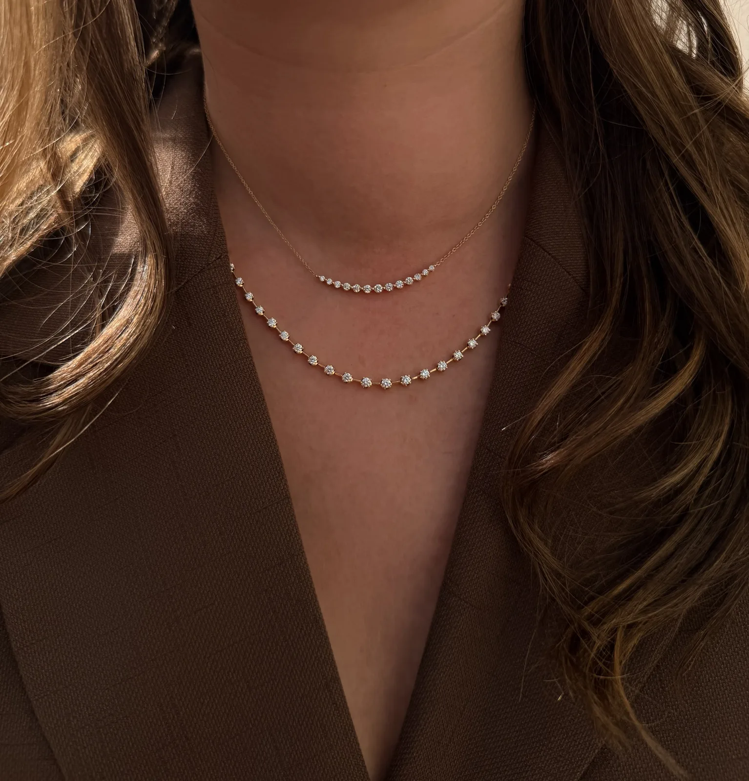 18k yellow gold diamond station necklace layered under a 14k yellow gold diamond smile necklace