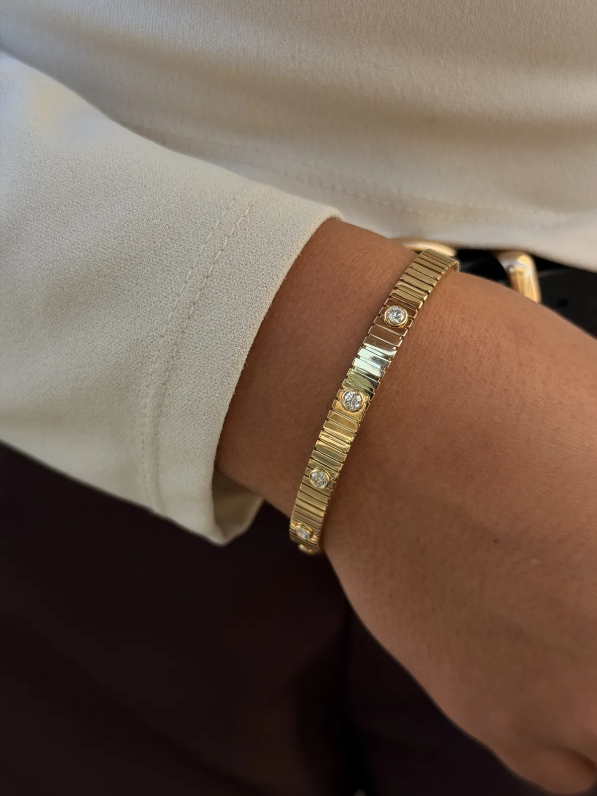 14k yellow gold bezel-set diamond striped bar flex bangle worn on the wrist