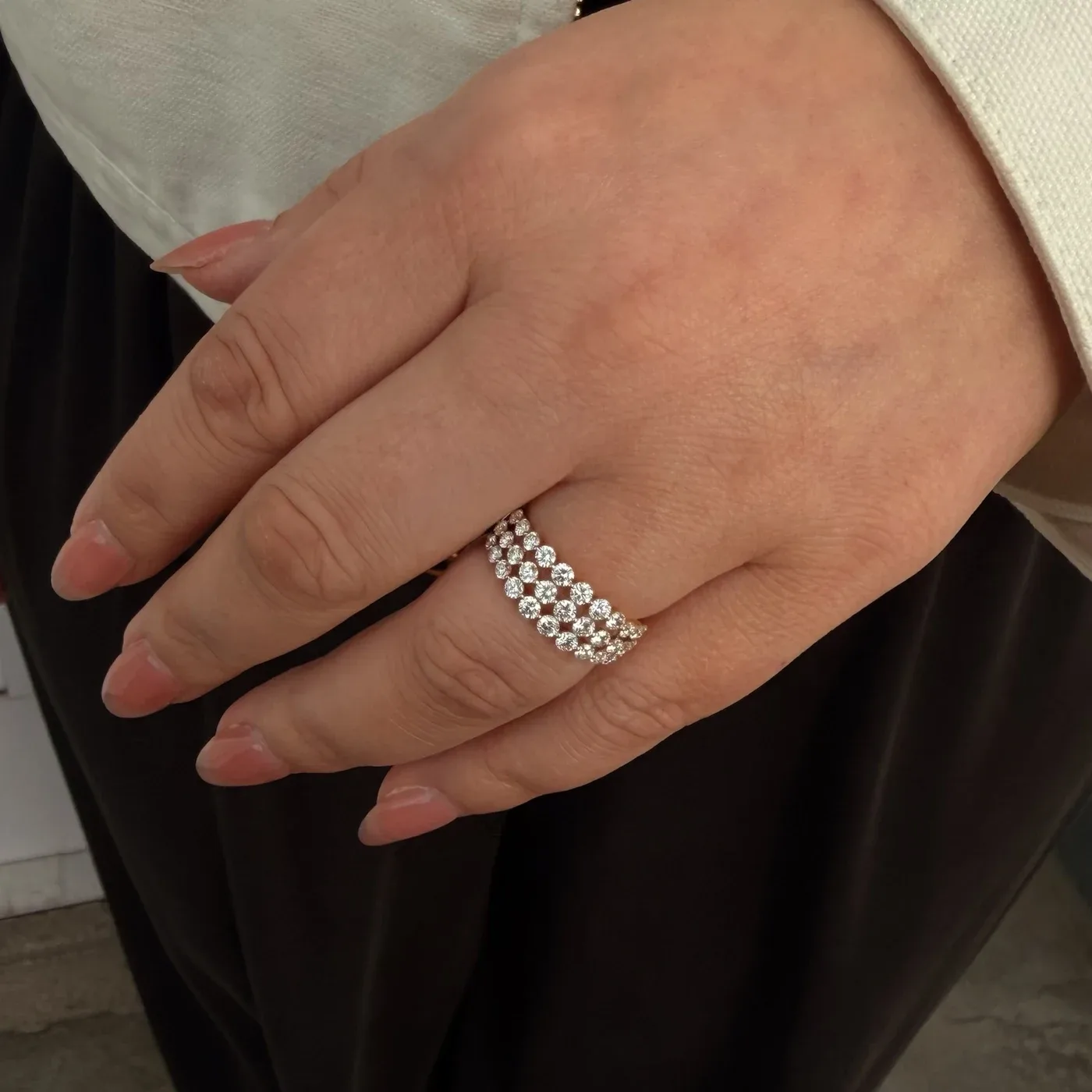 14k yellow gold 3-row diamond ring worn on the hand with an ivory sleeve