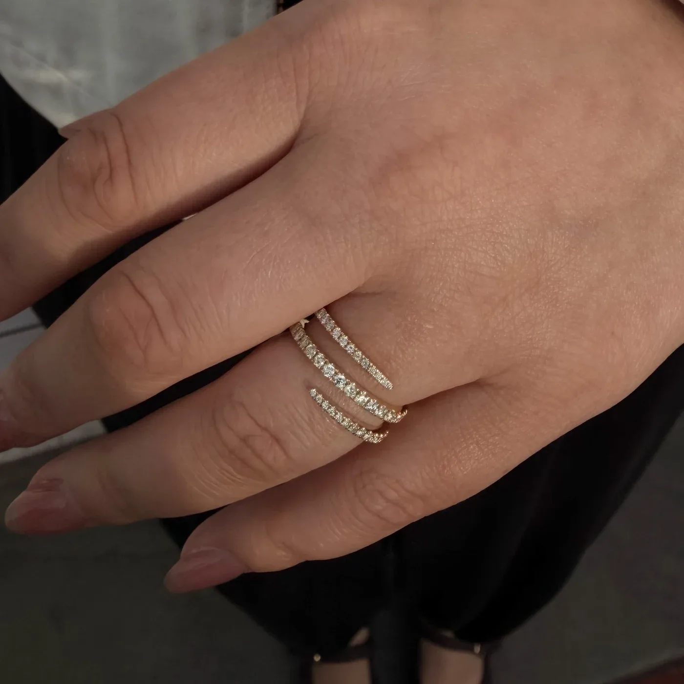 14k yellow gold triple-row bypass ring worn on the hand with an ivory sleeve